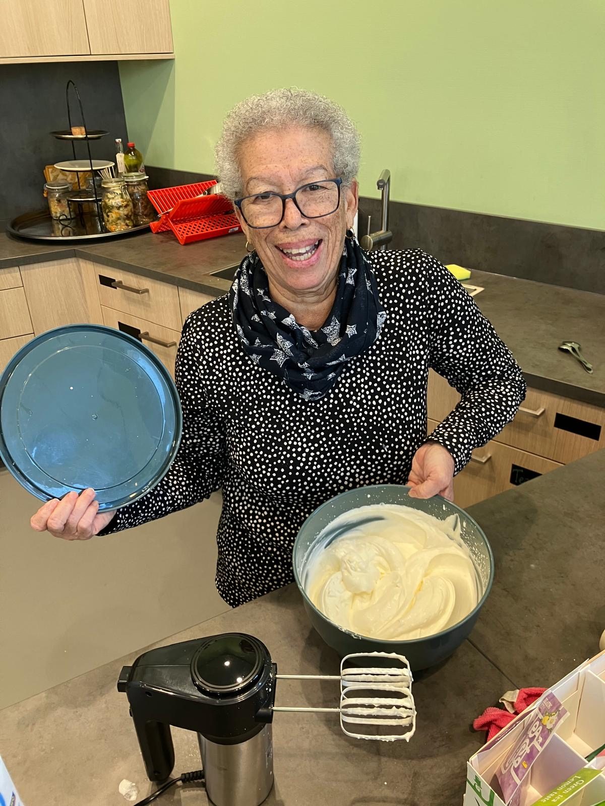 Een vrijwilliger bakt pannenkoeken in de keuken van de buurtkamer